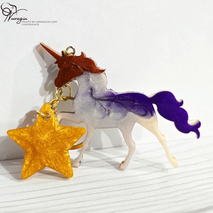 نمای پشت و جزئیات جاکلیدی یونیکورن رزینی مدل رنگارنگ همراه با آویز ستاره